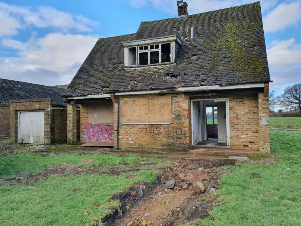 a large brick building with grass in front of a house