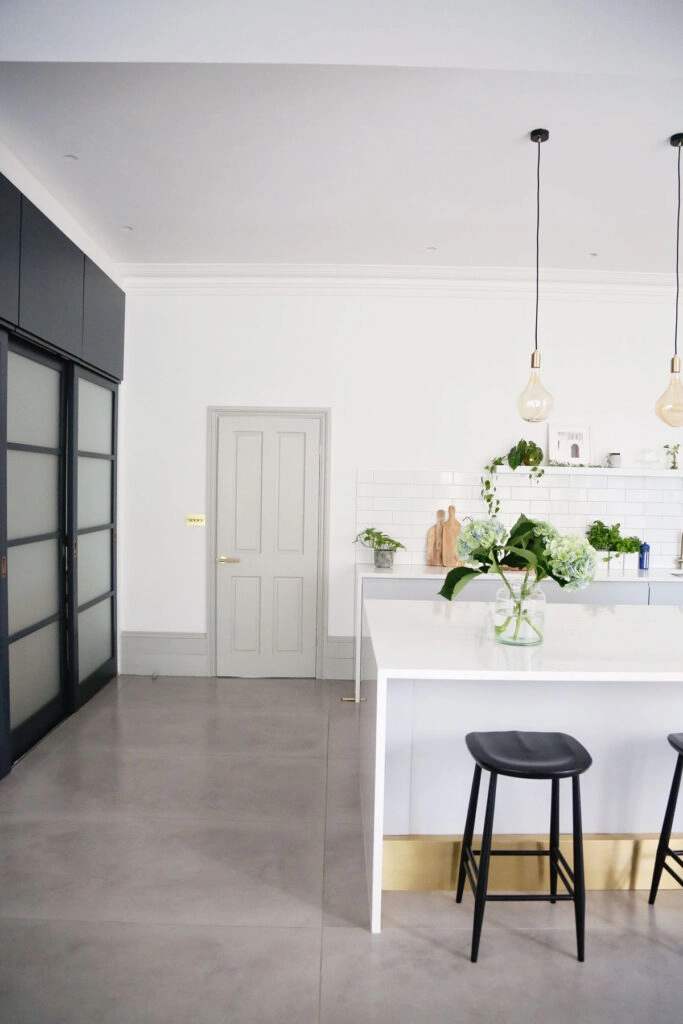 a room filled with furniture and vase of flowers on a table