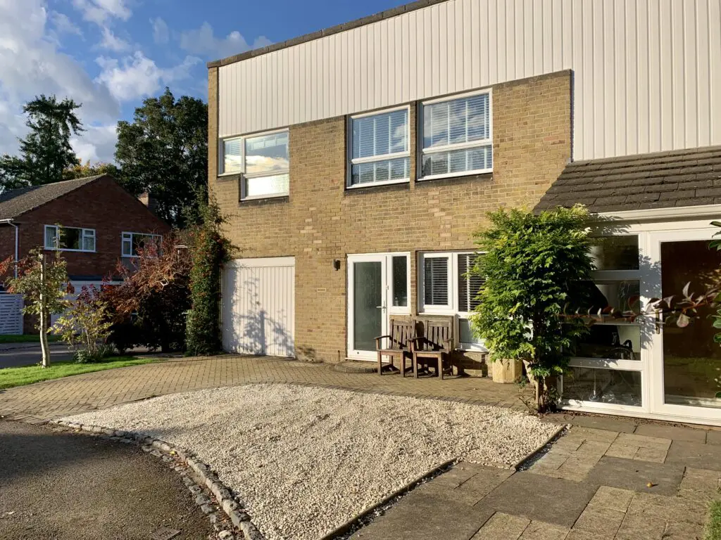 a small house in front of a brick building