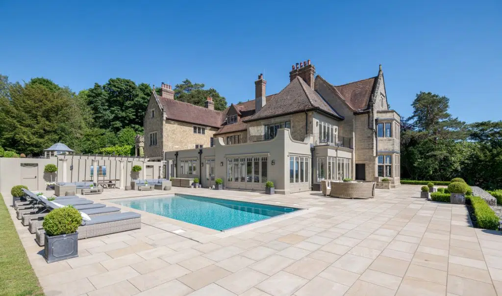 a large brick building with a pool in front of a house